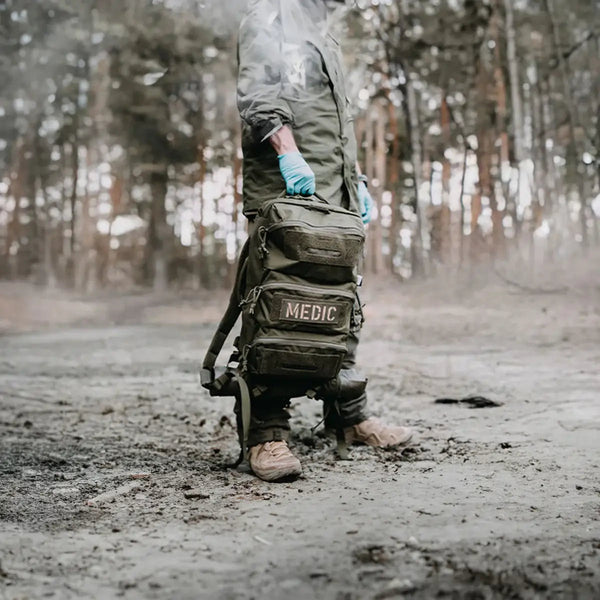 Eine Medizintasche die von einer Person nahe auf dem Boden gehalten wird.