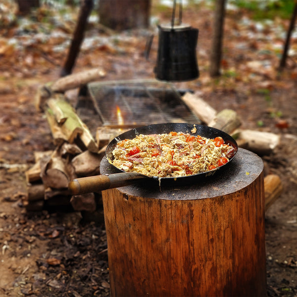 Bratpfanne mit Essen auf Baumstumpf